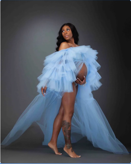 black woman in blue maternity dress at a photo shoot