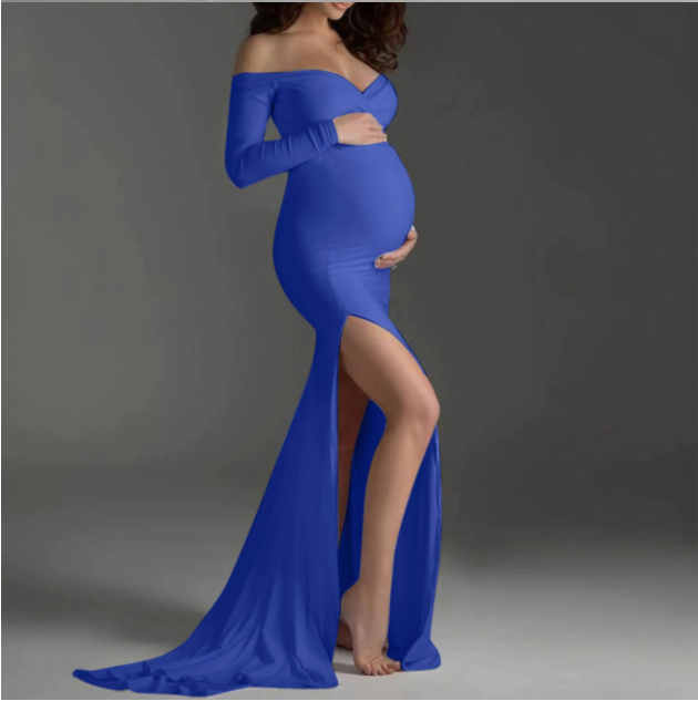 Pregnant woman in a long sleeve blue off the shoulder dress at a photoshoot