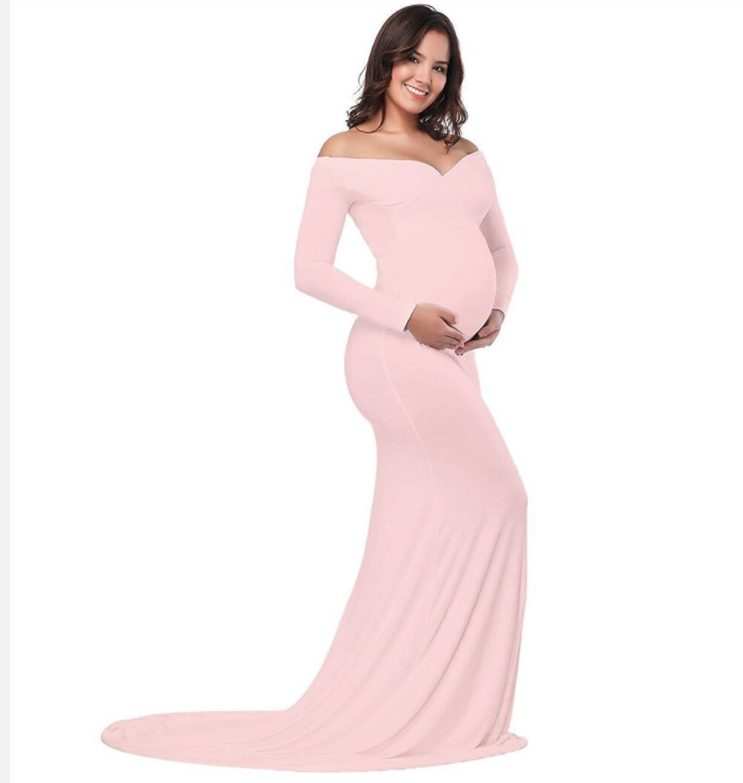 Pregnant woman in a long sleeve pink off the shoulder dress at a photoshoot