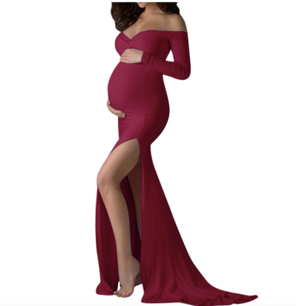 Pregnant woman in a long sleeve red off the shoulder dress at a photoshoot